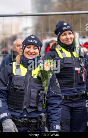 Rosenmontagszug in Düsseldorf, Einsatzkräfte, sichern, begleiten den Umzug, Polizistin mit geschenkten Blumen Sträußchen, Strüsschen, bei teils starkem Regen, NRW, Deutschland Rosenmontag DUS *** Rosenmontag Parade in Düsseldorf, Rettungsdienste, sicher, begleiten die Parade, Polizistin mit Blumensträußen, Sträußchen, bei teils starkem Regen, NRW, Deutschland Rosenmontag DUS Stockfoto
