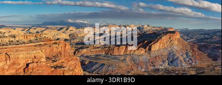 Dieses atemberaubende Winterpanorama des Capitol Reef National Park bietet sanftes Licht, das die malerische Waterpocket Fold bei Sonnenuntergang beleuchtet. Stockfoto