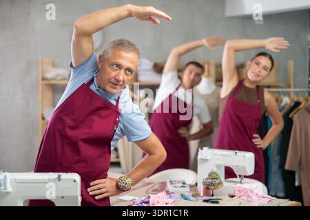 Schneider machen ein Aufwärmen in der Werkstatt Stockfoto