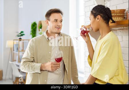 Nahaufnahme eines Paares, das Rotweingläser in gemütlicher Wohnküche tröstete Stockfoto