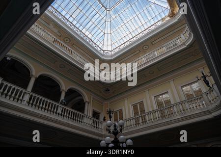 Cadiz, Spanien - 26. September 23: Blick nach oben auf ein Glasoberlichtdach über Innenbalkonen in einem historischen Atrium-Innenhof in Cádiz, Andalusien, Spanien, mit Stockfoto