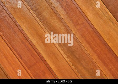 Nahaufnahme von lackierten Holzdielen, die diagonal angeordnet sind und warme Töne und natürliche Holzmaserung zeigen. Stockfoto