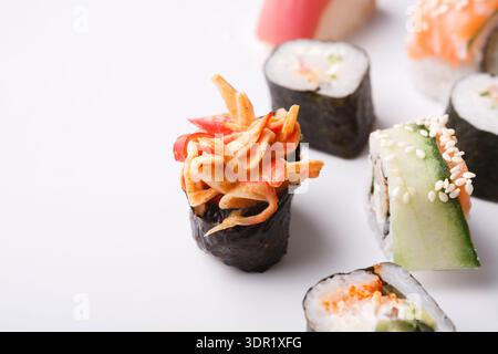 Sushi-Kollektion mit verschiedenen Arten von Sushi-Rolls im Mosaikstil auf einer Ebenen Oberfläche Stockfoto
