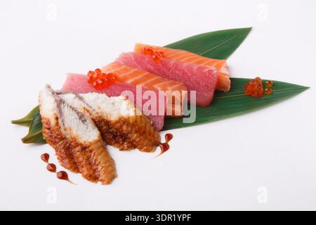 Sammlung von Sushi-Stücken auf einem Blatt mit dekorativen Elementen Stockfoto