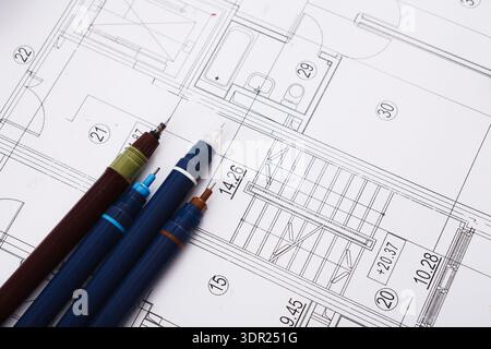 Collage von Architekturplänen mit Schreibwerkzeugen auf einer flachen Oberfläche in einer Arbeitsbereichseinstellung Stockfoto