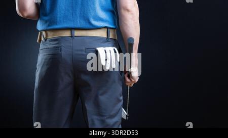 Rückansicht des Golfers mit Golfhandschuh in der Gesäßtasche und Schläger in der Hand Stockfoto