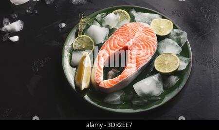 Sammlung von Lachsen auf Eis mit Limette auf dunkler Oberfläche in einer Küche Stockfoto