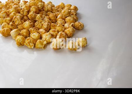 Karamell-Popcorn auf weißem Hintergrund mit Kopierraum für Snackkonzept Stockfoto