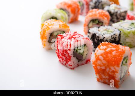 Bunte Sushi Rolls auf weißem Hintergrund mit verschiedenen Belägen und Füllungen Stockfoto
