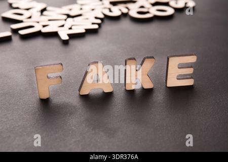 Buchstaben, die falsch geschrieben werden, sind auf einer dunklen Oberfläche angeordnet, wobei mehr Buchstaben verstreut sind Stockfoto