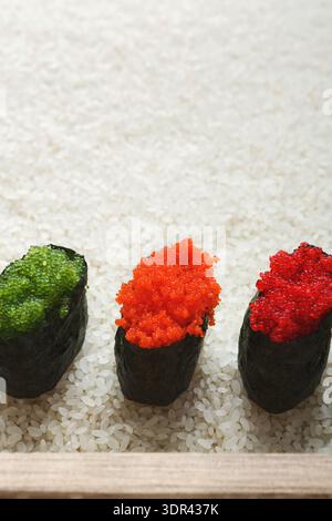 Verschiedene Arten von Sushi Rolls mit bunten Belägen auf einem Teller mit Reis Stockfoto