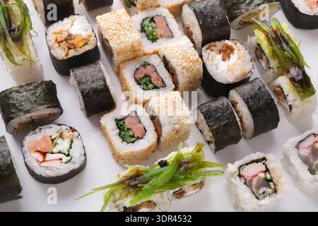 Sushi Collection Set mit verschiedenen Arten von Rollen und Zutaten auf einer weißen Platte Stockfoto