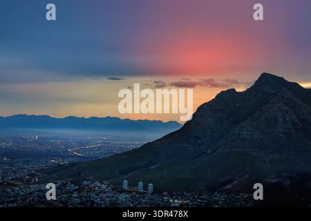 Aus der Vogelperspektive auf den majestätischen Tafelberg, der Schatten über die weitläufige Stadt unter einem lebendigen Sonnenuntergang wirft, Kapstadt, Westkap, Südafrika. Stockfoto