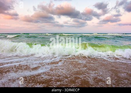 Stürmisches Wetter am Sandstrand. Dramatischer Himmel über dem Schwarzen Meer. moody Sommerlandschaft im Morgenlicht. Grüne Wellen schlagen die Küste ein. Majestätisch Stockfoto