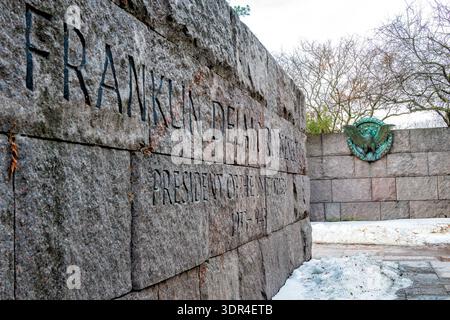 Franklin Delano Roosevelt Memorial Gravur Granitwand Bronze Eagle Medaillon Taue Schnee Washington DC // WASHINGTON, D.C. — schmelzende Schneelinien die gravierten Granitwände des Franklin Delano Roosevelt Memorial in der Nähe des Tidal Basin, Montag, 16. Februar 2026. Das 1997 eingeweihte und vom Landschaftsarchitekten Lawrence Halprin entworfene Denkmal ist aus rauhgehautem South Dakota-Granit, der von der Zeit verwittert wirken soll. Das bronzene Adlermedaillon, ein Relief des Präsidentensiegels, bildet einen starken materiellen Kontrast zu den massiven Steinblöcken, die die vier unterschiedlichen Außenbereiche der Gedenkstätte definieren Stockfoto