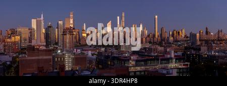 Der Sonnenaufgang spiegelt sich auf Glashochhäusern über Manhattans East Side von einem hohen Panoramablick. Stockfoto