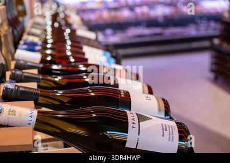 Penang, Malaysia – 15. April 2025: Mehrere Reihen von Weinflaschen sind ordentlich in Regalen in einem Geschäft angeordnet und präsentieren verschiedene Marken Stockfoto