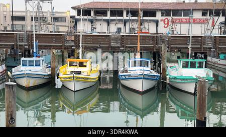 Farbenfrohe Fischerboote liegen nebeneinander an einem Yachthafen entlang der Küste von San Francisco in Kalifornien, USA Stockfoto