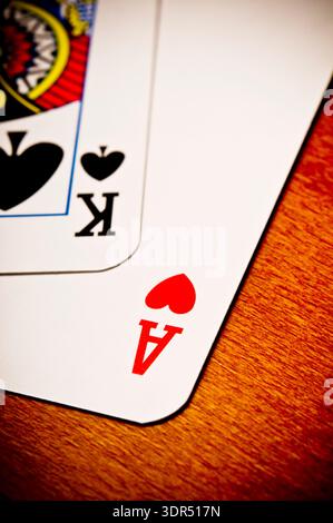 Nahaufnahme von Herz-Ass und Pik-König auf Holztisch, Poker-Glücksspiel-Thema Stockfoto