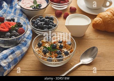 Frühstück mit Joghurt, Obst und Croissants auf Holztisch Stockfoto