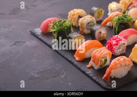 Sushi-Kollektion auf einem Teller mit verschiedenen Arten von Rollen und Stücken Stockfoto