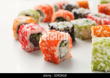 Verschiedene Sushi Rolls auf einem weißen Teller in einem Sushi Restaurant während des Mittagessens Stockfoto