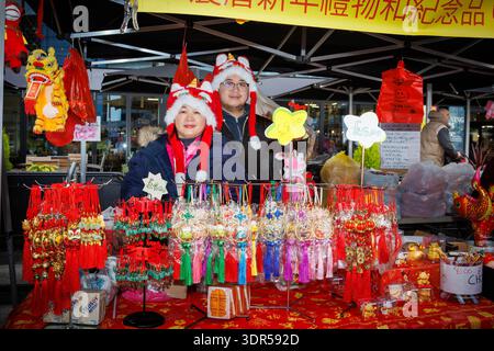 Das Mondneujahrsfest 2026 auf dem Time Square in Warrington feiert das Jahr des Pferdes. Warrington Hongkonger veranstalten eine Show mit Drachentanz, traditionellen Ständen mit Kunsthandwerk, chinesischem Spielzeug und Geschenken sowie Street Food. Klassische Hong Kong Karnevalspiele waren ebenso erhältlich wie kulturelle Erlebnisse wie Fai Chun, chinesische Kalligrafie und Wahrsager. Ein paar Chinesen in Drachenhüten posieren für ein Bild auf ihrem Stand, das chinesische Geschenke verkauft. Quelle: John Hopkins/Alamy Live News Stockfoto