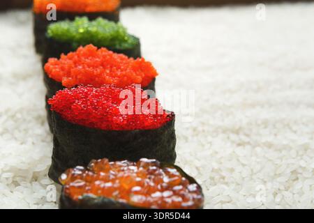 Köstliche Sushi Rolls mit bunten Belägen auf Reis in einem Restaurant-Setting Stockfoto