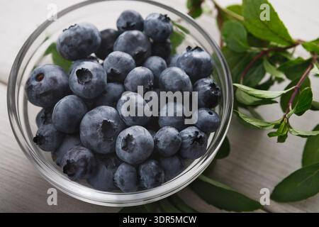 Frische Heidelbeeren in einer durchsichtigen Schüssel, bereit zum Kochen oder Snacken auf einem Tisch Stockfoto