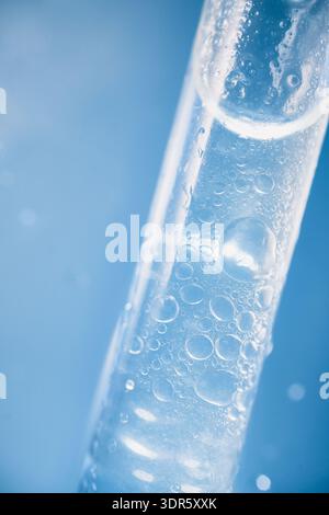 Teströhrchen oder Pipette mit transparenter Flüssigkeit, mit vielen kleinen Luftblasen Stockfoto