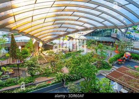 Modernes Einkaufszentrum in Bangkok City mit grünen Terrassen, Fußgängerwegen, Café und Restaurants unter Glasdach. Integration Stockfoto