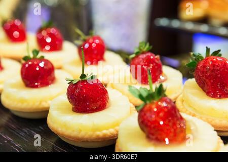Obsttörtchen mit Ananas und frischen Erdbeeren. Köstliche frische Obstkuchen zum Nachtisch, gesunde Esskonzepte. Stockfoto