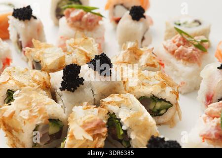 Frische Sushi Rolls mit verschiedenen Zutaten serviert auf einem weißen Teller in einem Restaurant Stockfoto
