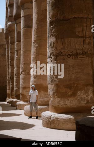 Mann, der vor den Säulen des Karnak-Tempels steht, Luxor, Oberägypten, Ägypten Stockfoto