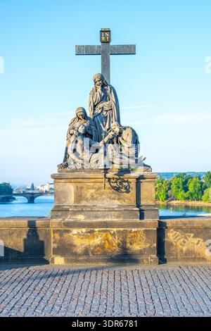 Die Statue von Piet zeigt die Klage Christi. Es steht an der Karlsbrücke in Prag mit Blick auf den Fluss und die Stadt. Besucher bewundern oft die detaillierten Arbeiten an der Statue. Stockfoto