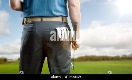 Rückansicht eines Golfers, der ein Eisen hält, mit einem Golfhandschuh in der Gesäßtasche Stockfoto