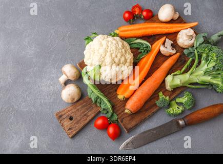 Frisches Gemüse auf einem Holzbrett zur Zubereitung von Mahlzeiten in der Küche Stockfoto