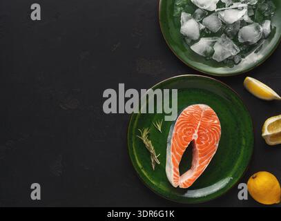 Frisches Lachssteak auf grünen Tellern mit Eis- und Zitronenscheiben zum Kochen oder Servieren Stockfoto