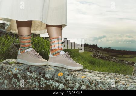 Nahaufnahme von farbenfrohen Stricksocken aus Wolle, die auf antiken Ruinen in Hierapolis mit einem bewölkten Himmel ruhen. Stockfoto