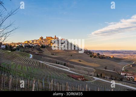 Winterberge in Langhe, Piemont, Italien, mit sanften Hügeln und einem Dorf auf einem Hügel unter weichem Nebel – stimmungsvolle ländliche Landschaft ideal für Weintourismus Stockfoto