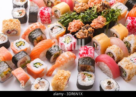 Farbenfrohe Sushi-Kollektion in einem Mosaik auf einer weißen Oberfläche zur Anzeige angeordnet Stockfoto