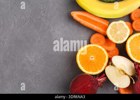 Frisches Obst und Gemüse auf grauer Oberfläche mit farbenfroher Anzeige bei Tageslicht Stockfoto