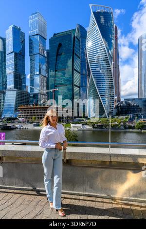 Die Skyline der Stadt vom Fluss aus mit einer stilvollen Frau in einer wunderschönen urbanen Szene Stockfoto