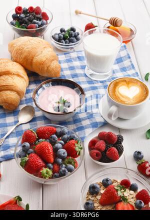 Genießen Sie morgens ein Frühstück mit Obst, Joghurt und Kaffee auf einem Tisch Stockfoto