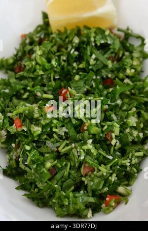 Traditioneller Tabbouleh-Salat mit Petersilie, Minze, Tomaten, Bulgur-Weizen, fein gehacktem Gemüse, pikantes Dressing und Zitrone. Oman Stockfoto