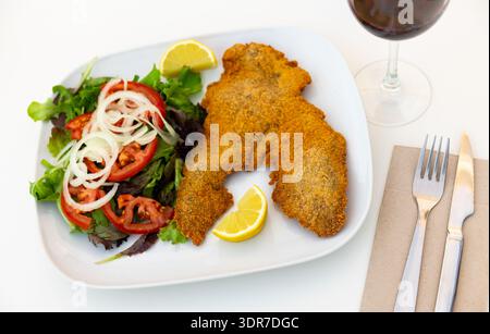 Portion panierter Schnitzel, Milanesa, mit Salat auf dem Tisch Stockfoto
