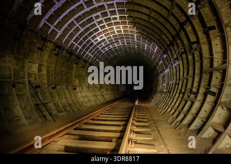 Runder unterirdischer U-Bahn-Tunnel mit Tubing. Stockfoto