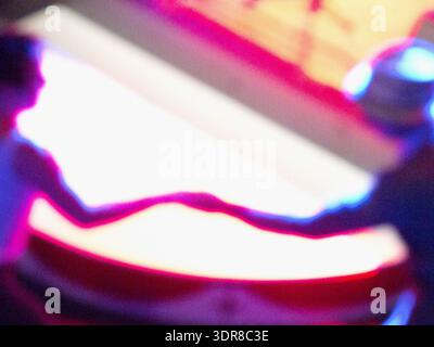 Lebendige Bewegungsunschärfe fängt ein Paar ein, das in einem neonbeleuchteten Veranstaltungsort tanzt und das energiegeladene Nachtleben und den kulturellen Geist eines Reisenden widerspiegelt. Stockfoto