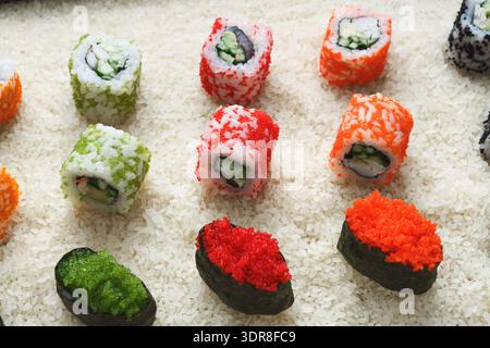 Farbenfrohe Sushi Rolls auf einem Reisbett in einem Sushi Restaurant während der Mittagszeit Stockfoto