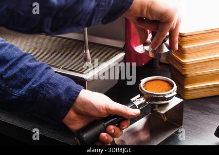 Kaffeezubereitung in einem geschäftigen Café mit Tools und Ausrüstung für die Zubereitung von Espresso Stockfoto